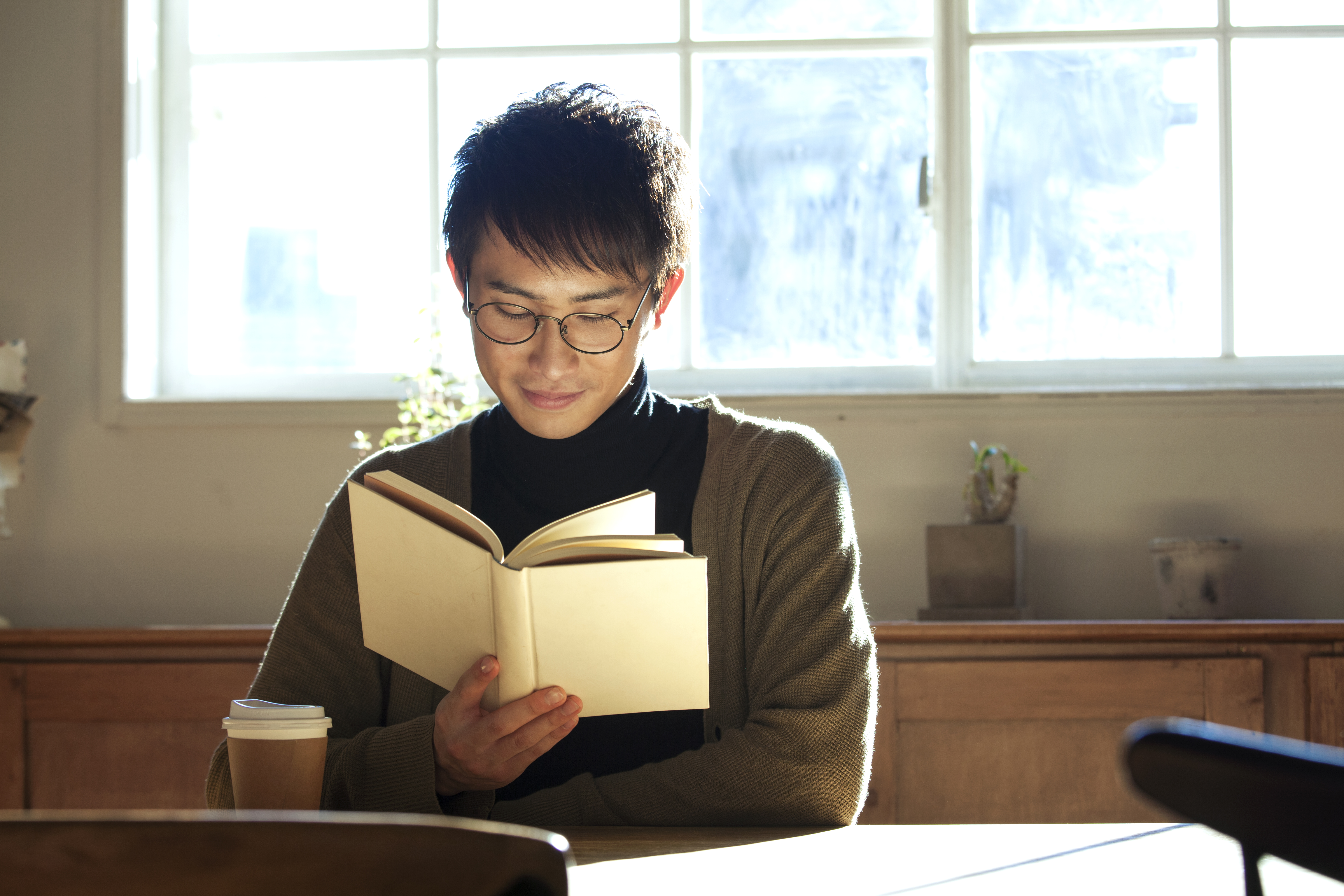 An open book beside a cup of coffee